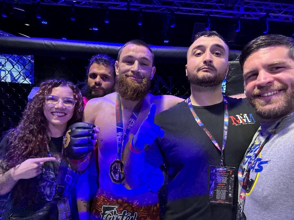 Combat Night victory celebration with gold medal in the cage